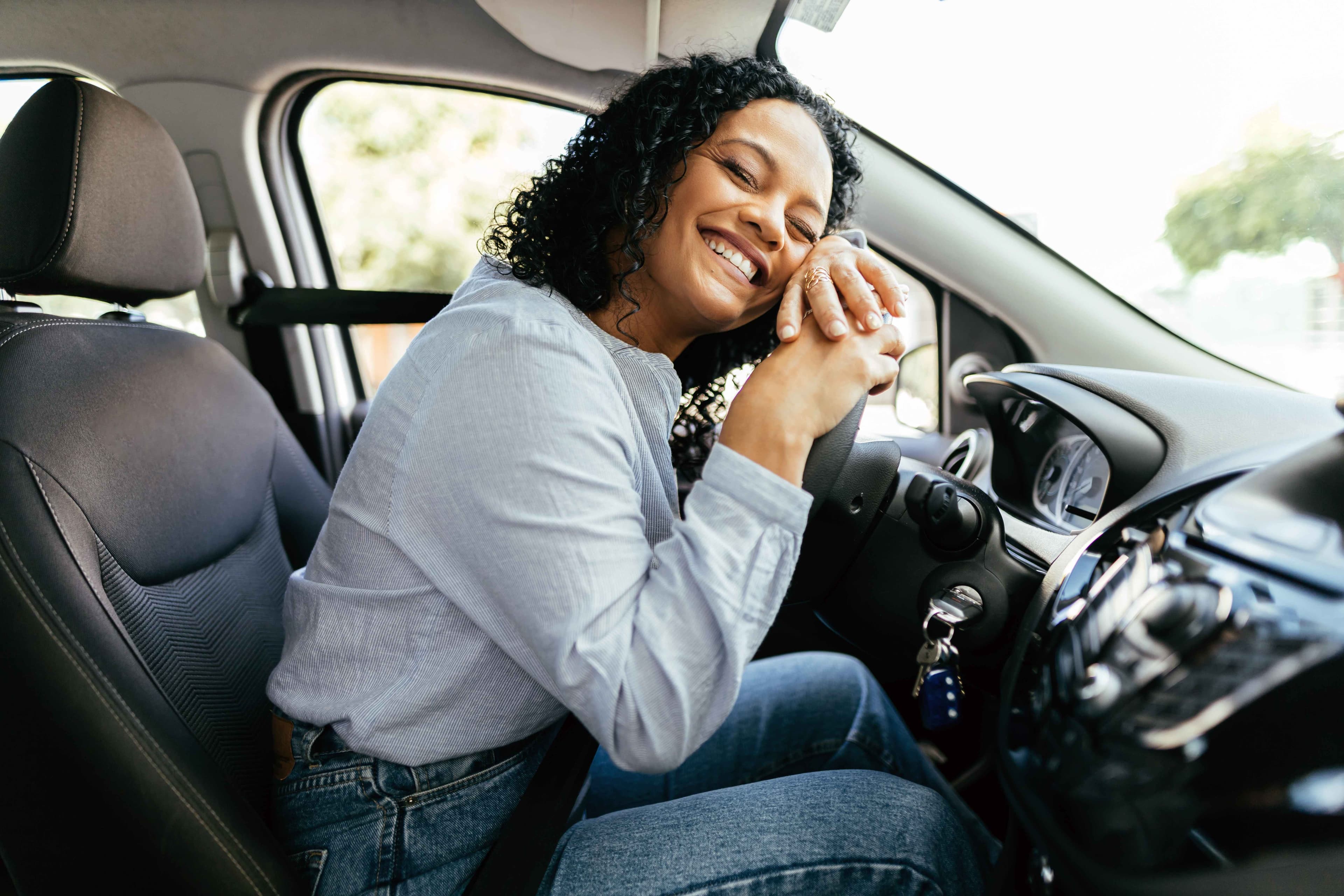 Happy customer celebrating in her new car with AutoBreeze concierge service